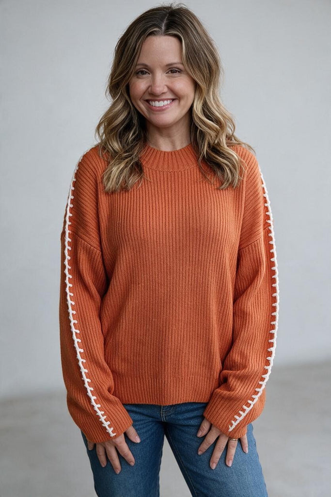 pumpkin orange sweater with white exposed seams