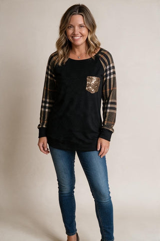 black sweater with olive plaid sleeves, and a sequin pocket