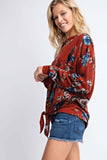 maroon blouse with floral print and a boat neckline 