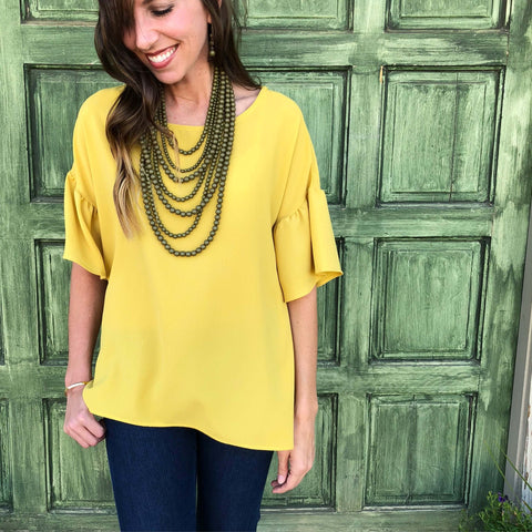 Mustard blouse with bell ruffle sleeves in our boutique aunt lillie bells