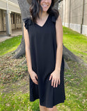 black sleeveless shift dress with ruffle trim on the shoulders